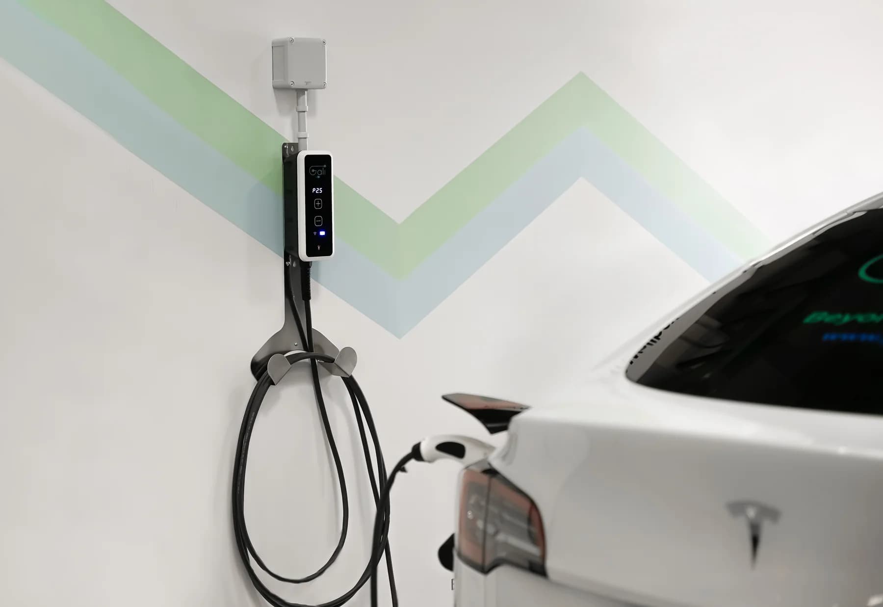 GALI BC mounted on a wall, plugged into a white electric car